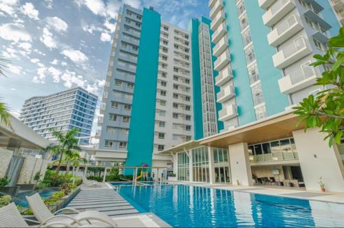 a swimming pool in front of some buildings at TJs Oasis at Mesavirre Garden Residences in Bacolod