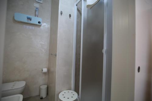 a white bathroom with a shower and a toilet at Affittacamere in Piazzetta in Sarzana