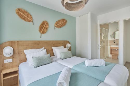 a bedroom with two beds with white and blue at Résidence Odalys Riviera in Hyères