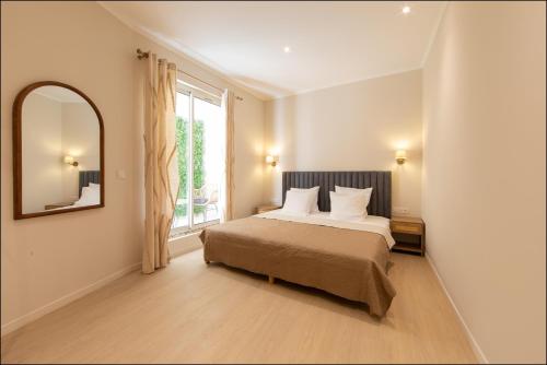 a bedroom with a bed and a large window at Hotel Villa Botanica in Cannes