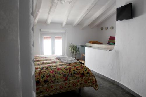 Habitación blanca con cama y ventana en Casa Baraka, en Algodonales