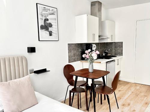 une cuisine avec une table et des chaises dans une pièce dans l'établissement Résidence des Halles - Flat, à Paris