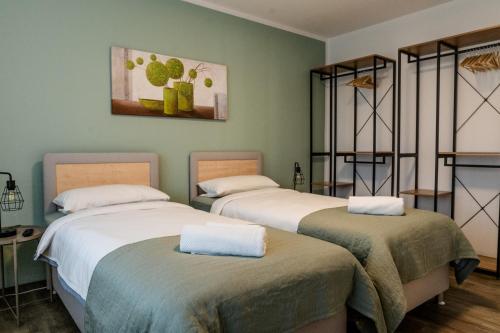 two beds in a room with green walls at janu-homes - 2 Zimmer Apartment - 4 Betten, Lahnblick vom Amselweg in Runkel