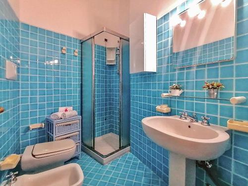 y baño de azulejos azules con lavabo y ducha. en Porto Cervo Residence Vistamare, en Porto Cervo