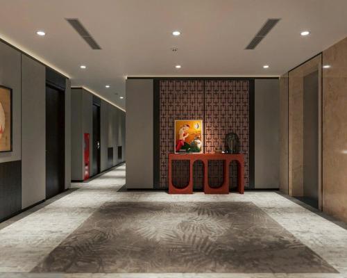 a hallway with a table and a painting on the wall at Minasi Grand Hotel in Hanoi