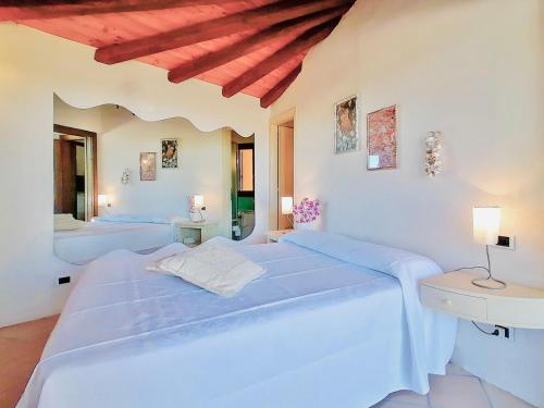 2 camas en un dormitorio con paredes blancas en Porto Cervo Residence Vistamare, en Porto Cervo