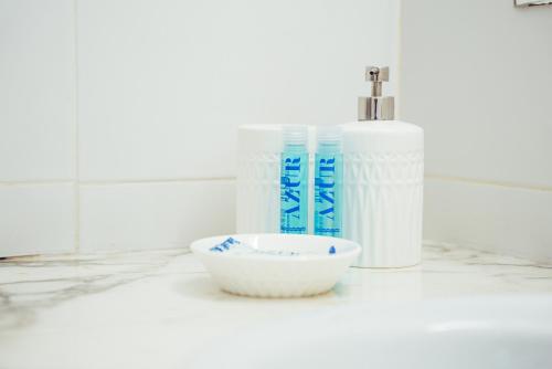 カレタ・デ・ファマラにあるFamara Home Beachの2本のボトルとボウルが置かれた白いカウンター