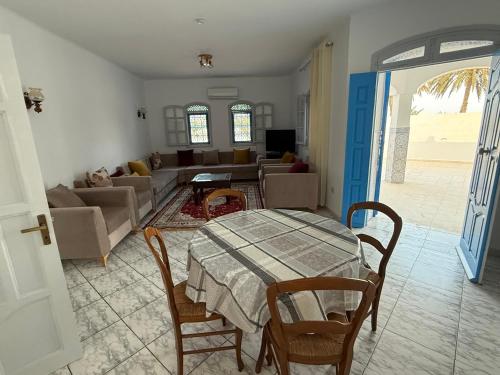 a living room with a table and a couch at Villa FTIMA in Mezraya