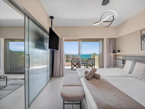 a hotel room with two beds and a couch at Creta Star Hotel - Adults Only in Skaleta
