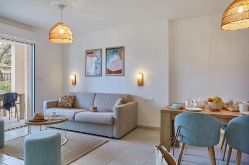 a living room with a couch and a table at Résidence Odalys Riviera in Hyères