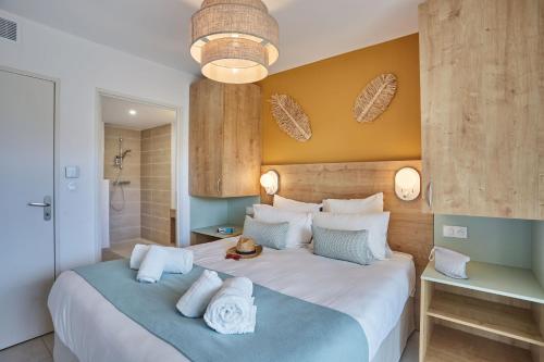 a bedroom with a large white bed with blue accents at Résidence Odalys Riviera in Hyères