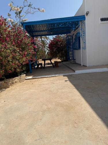 a pavilion with a picnic table in front of a building at Villa FTIMA in Mezraya