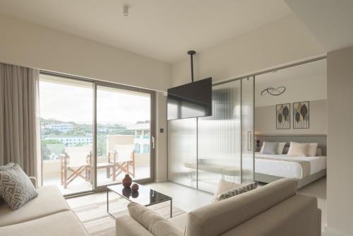 a living room with a couch and a bed and a table at Creta Star Hotel - Adults Only in Skaleta