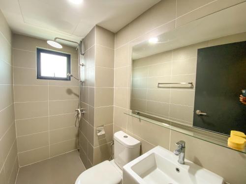 a bathroom with a toilet and a sink and a mirror at Cozy Emira Home 3 Bedrooms in Shah Alam