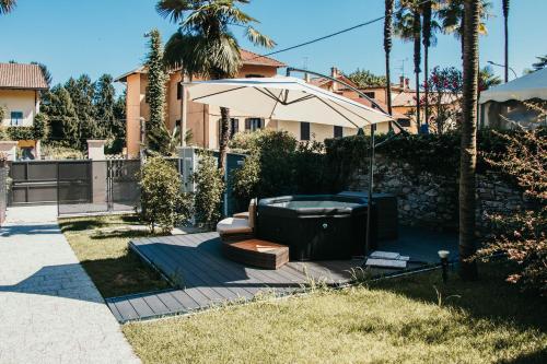 a backyard with a bathtub and an umbrella at Gio Leo Guest House in Lesa