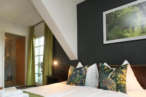 a bedroom with a bed with white sheets and pillows at Seehotel Sissi in Zell am See
