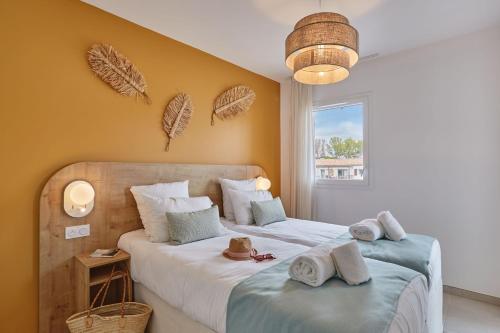 a bedroom with two beds with hats on them at Résidence Odalys Riviera in Hyères