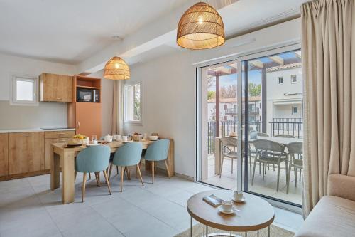 a kitchen and living room with a table and chairs at Résidence Odalys Riviera in Hyères