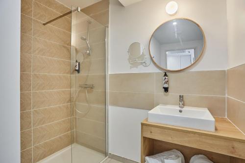 a bathroom with a shower and a sink and a mirror at Résidence Odalys Riviera in Hyères