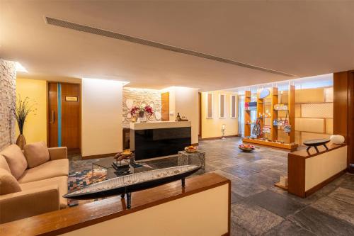 a living room with a couch and a fireplace at Radisson Resort Hatgad Saputara in Saputara