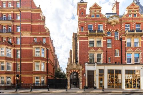 a large brick building next to two tall buildings at Kensington High Street Suites in London
