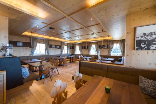 a restaurant with wooden ceilings and tables and chairs at BichlAlm Berggasthof in Kitzbühel