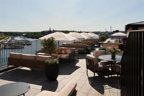 a row of tables and chairs on a rooftop patio at Radisson Collection, Strand Hotel, Stockholm in Stockholm