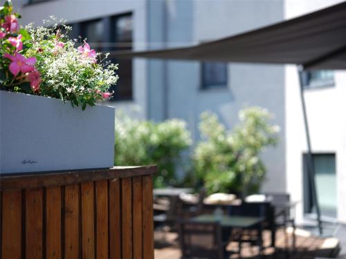 a planter with flowers on a wooden fence at Park Inn by Radisson Luxembourg City in Luxembourg