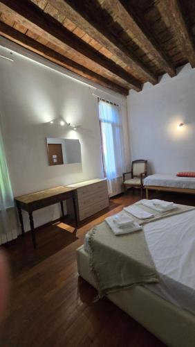 a bedroom with a bed and a desk with a mirror at Ca' Amore Venezia in Venice