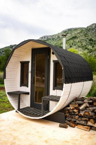 a circular house with a black roof on a pile of rocks at Villa Aurea in Neum