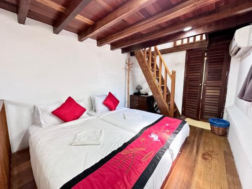 a bedroom with a large bed with red pillows at 26 Rangoon Residence 26 in George Town