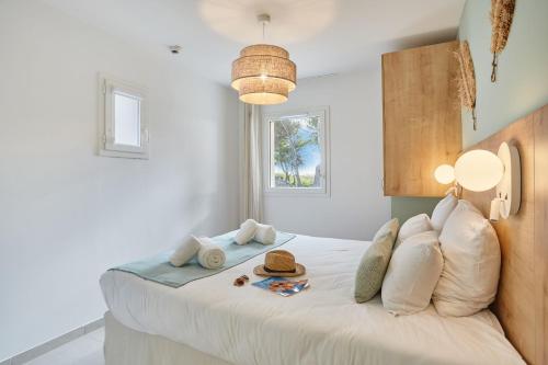 a bedroom with a large white bed with white pillows at Résidence Odalys Riviera in Hyères