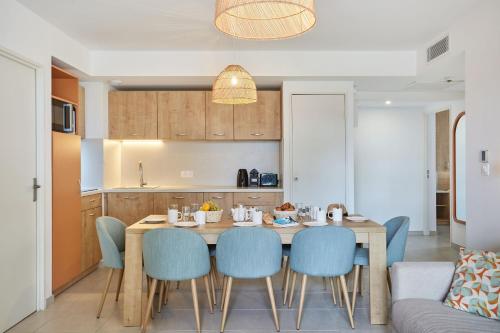 a kitchen and dining room with a table and chairs at Résidence Odalys Riviera in Hyères