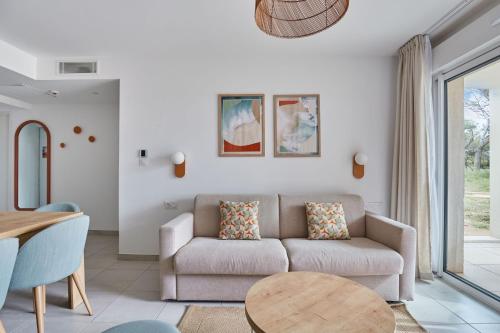 a living room with a couch and a table at Résidence Odalys Riviera in Hyères
