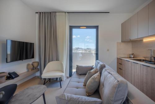 a living room with a couch and a kitchen at Sokio Attiki Hotel, BW Premier Collection in Athens