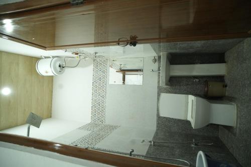 baño pequeño con ducha y lavamanos en SRINIVASA Home stay, en Rishīkesh