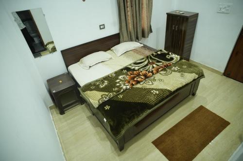 Un dormitorio con una cama con un edredón verde. en SRINIVASA Home stay, en Rishīkesh