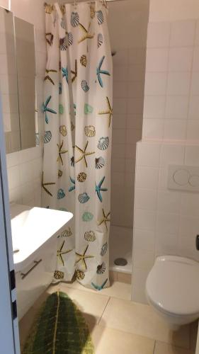a bathroom with a shower curtain with fish on it at Studio mit schöner Aussicht in Bad Rothenfelde