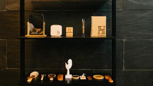 a shelf with cosmetics and a cat sitting on it at H Hotel El Nido - Vegan Friendly Hotel Managed by H Hospitality Group in El Nido