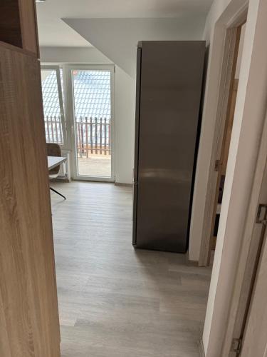 a stainless steel refrigerator in a room with a balcony at Sóstó Suites in Nyíregyháza