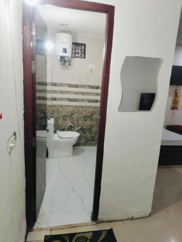 a bathroom with a toilet and a glass door at Mohit guest In in Vrindāvan