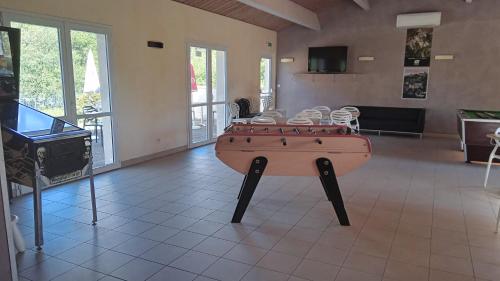 a room with a ping pong table in the middle at Terres de France - Les Hameaux de Pomette in Marminiac