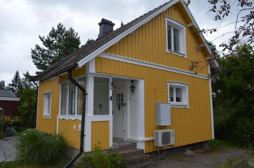 a yellow house with a white door at Humlebo in Boda Glasbruk