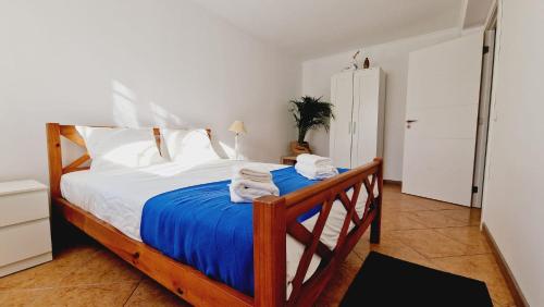 a bedroom with a bed with towels on it at Lazaro Beach House in Faro