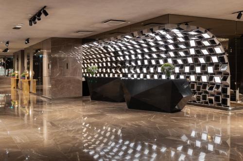 a lobby with a stone wall and a table in the middle at EPIC SANA Marquês Hotel in Lisbon