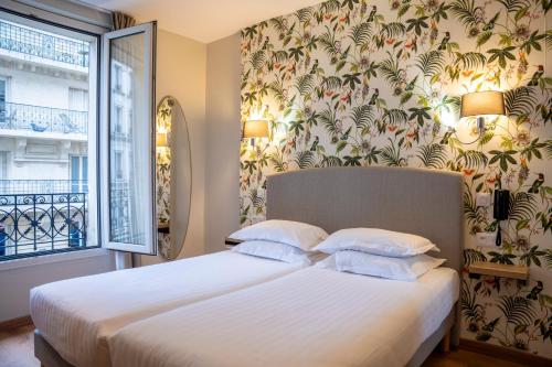 a bedroom with a bed with white sheets and a window at Verlain in Paris