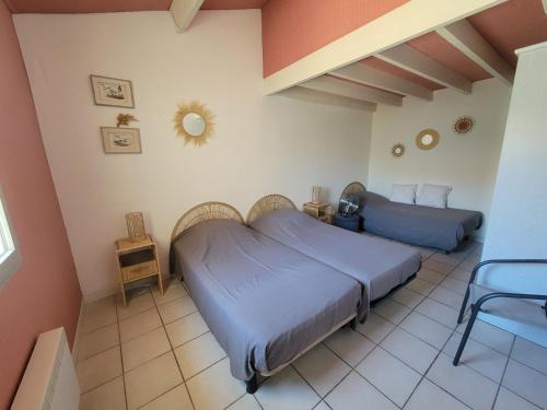 une chambre avec un lit et une chaise dedans dans l'établissement Villa 5 couchages 2 chambres belle terrasse d'angle piscine commune dans résidence sécurisée à 200m de la mer LRMA2A, à Portiragnes