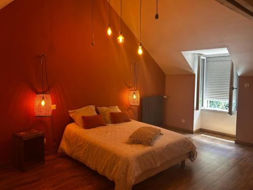 a bedroom with a bed and a window and lights at La Maison du Marinier in Crouzilles