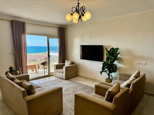 a living room with couches and a flat screen tv at ALEX HOMES - Sporting Sidi Gaber Cozy Apartments with Direct Sea View - Families only in Alexandria