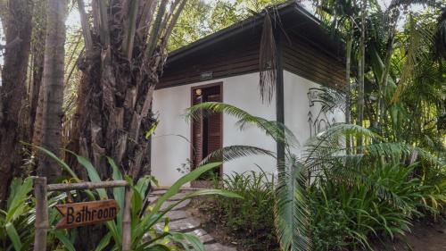a small house in the jungle with a sign in front of it at Nacpan Beach Glamping Managed by H Hospitality Group in El Nido
